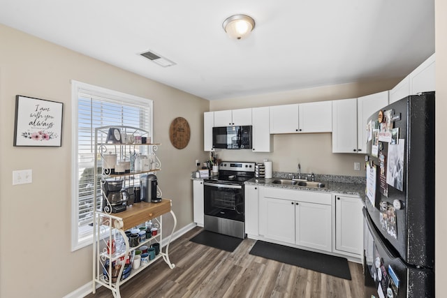 kitchen with sink, black appliances, and white cabinetry