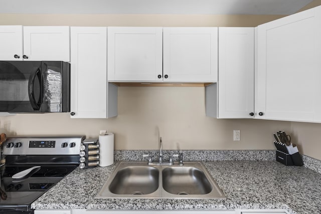 kitchen featuring sink, white cabinetry, stainless steel electric range oven, and light stone counters