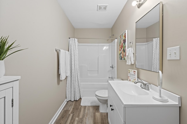 full bathroom featuring vanity, hardwood / wood-style flooring, shower / bath combo with shower curtain, and toilet