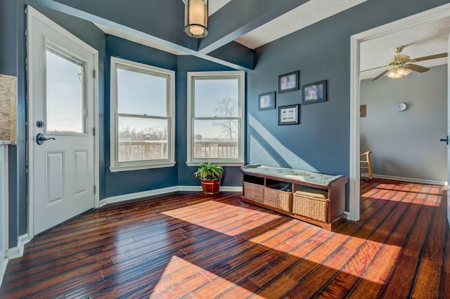 foyer entrance featuring dark wood-type flooring, a textured ceiling, beam ceiling, and ceiling fan