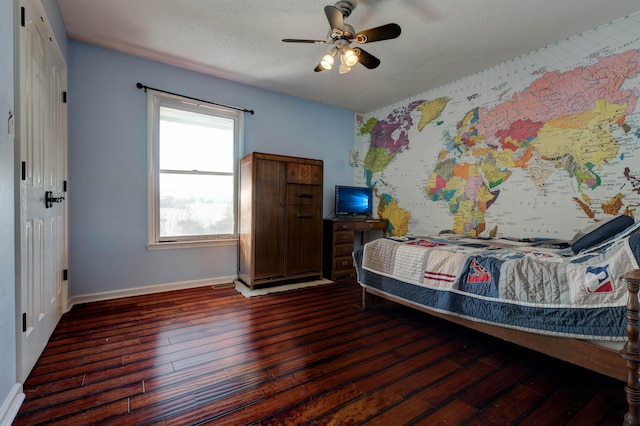 bedroom with ceiling fan, a textured ceiling, and dark hardwood / wood-style floors