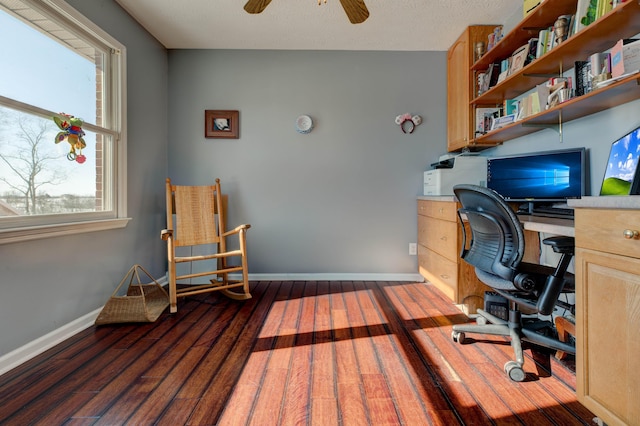 office space featuring ceiling fan, a wealth of natural light, and dark hardwood / wood-style floors