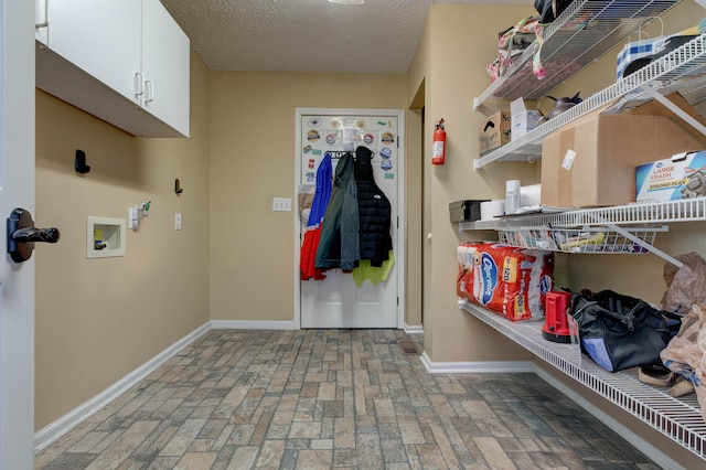 laundry area featuring hookup for a washing machine, cabinets, and a textured ceiling