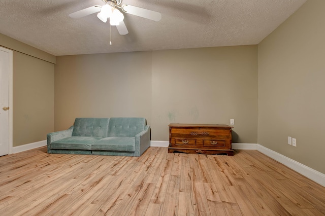 sitting room featuring ceiling fan, a textured ceiling, and light wood-type flooring