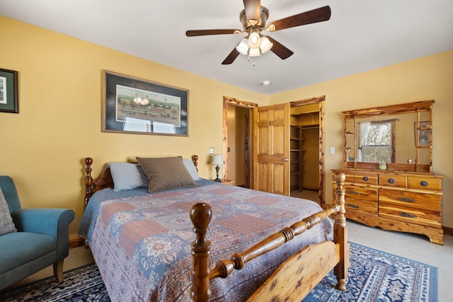 bedroom with carpet floors, a spacious closet, ceiling fan, and a closet