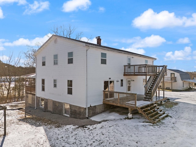 snow covered property with a deck