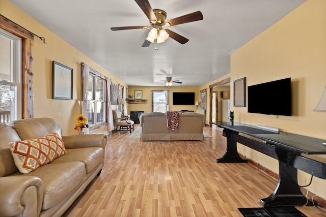 living room featuring ceiling fan and light hardwood / wood-style floors