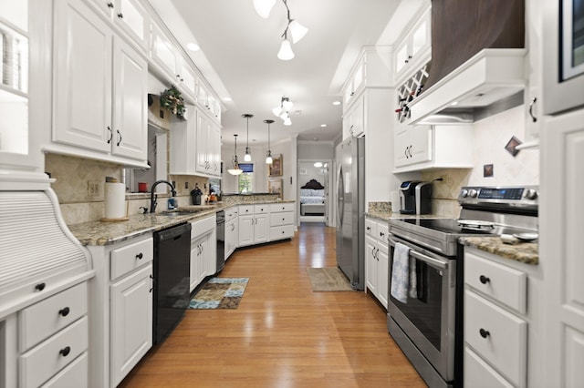 kitchen with pendant lighting, white cabinetry, sink, decorative backsplash, and stainless steel appliances