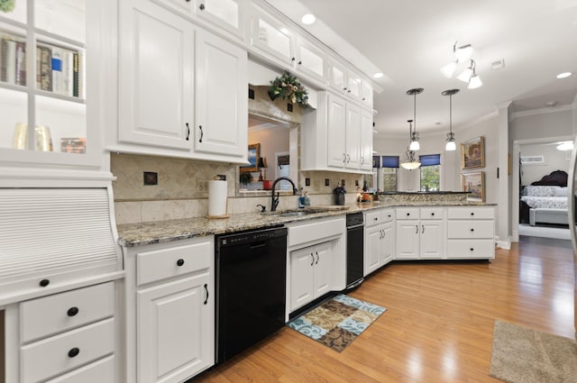 kitchen featuring white cabinetry, hanging light fixtures, sink, and black dishwasher