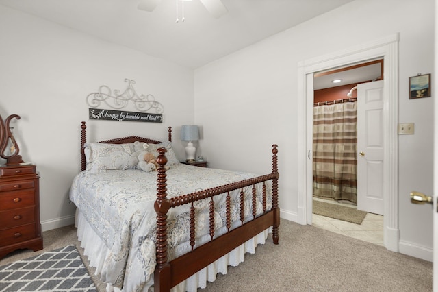 bedroom with ensuite bath, light colored carpet, and ceiling fan