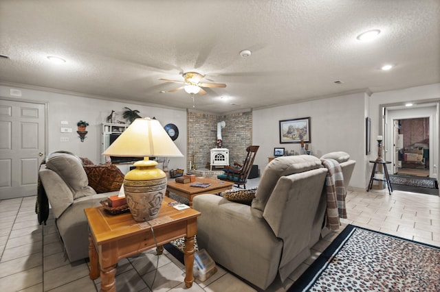 tiled living room featuring ceiling fan, ornamental molding, and a textured ceiling