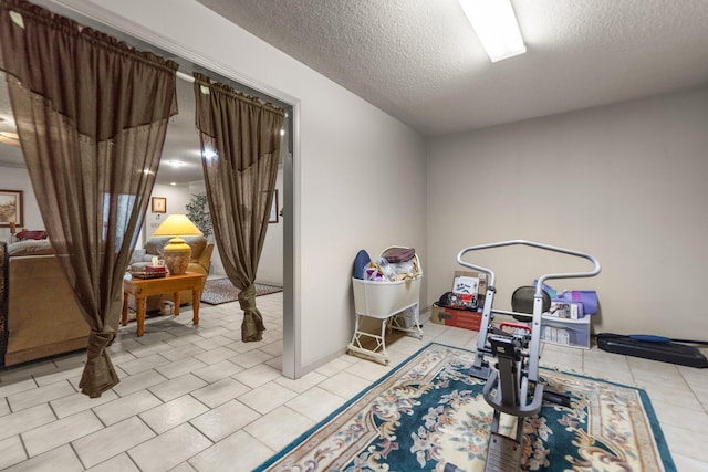 game room featuring light tile patterned floors and a textured ceiling