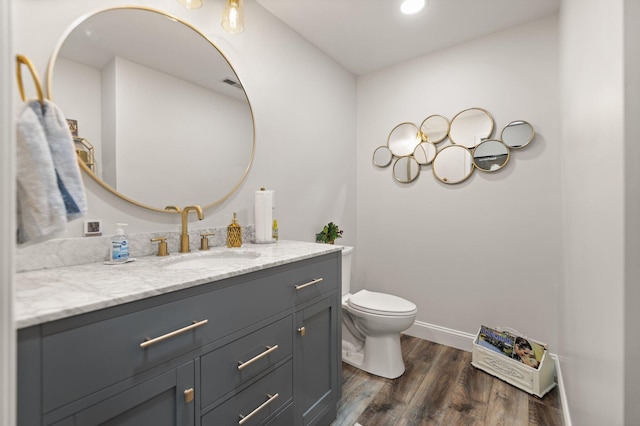 bathroom with vanity, wood-type flooring, and toilet