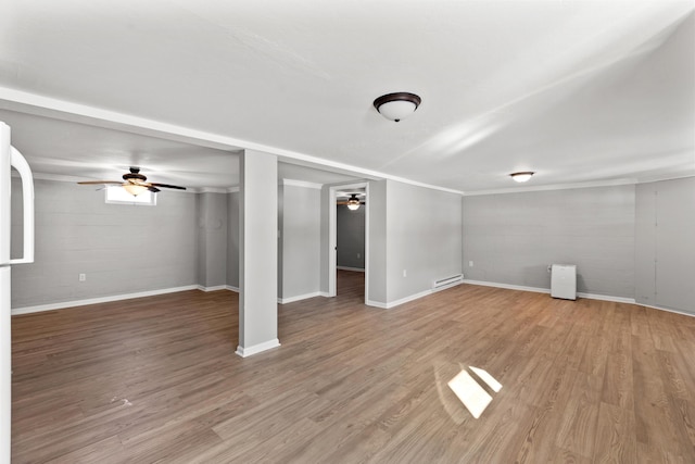 basement with ceiling fan, baseboard heating, and wood-type flooring