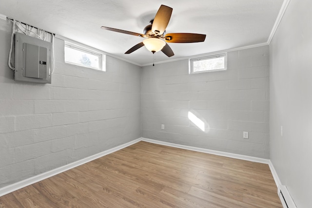 spare room with crown molding, a baseboard radiator, light wood-type flooring, ceiling fan, and electric panel