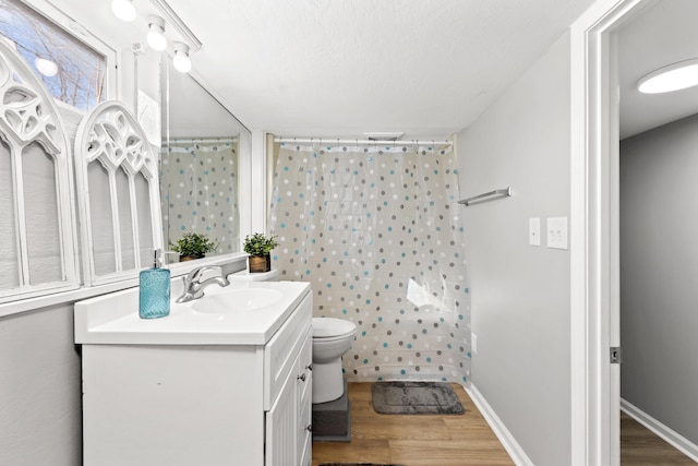 bathroom with wood-type flooring, toilet, walk in shower, and vanity