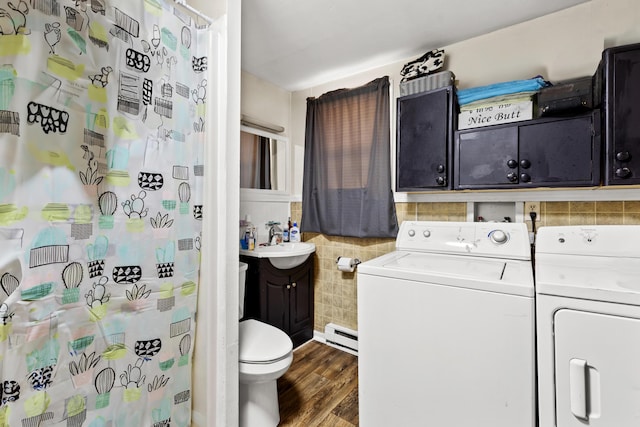 interior space with wood-type flooring, a baseboard heating unit, tile walls, separate washer and dryer, and toilet