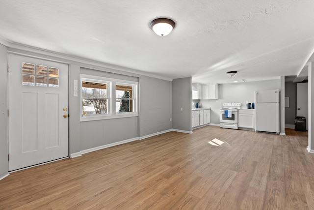 unfurnished living room with light hardwood / wood-style floors and a textured ceiling