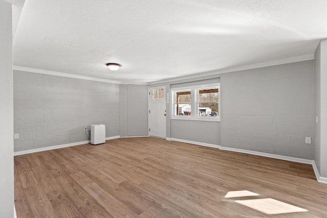 empty room with light hardwood / wood-style floors, a textured ceiling, and ornamental molding