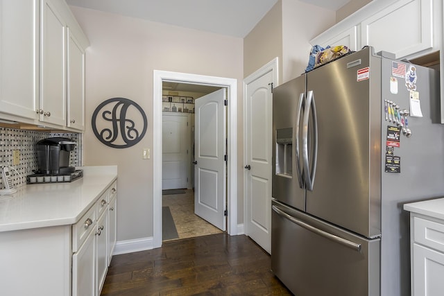 kitchen featuring light countertops, white cabinets, stainless steel fridge, and dark wood finished floors