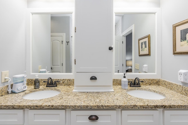 full bathroom with double vanity and a sink