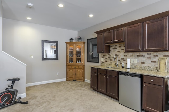 kitchen featuring light carpet, dishwasher, a sink, dark brown cabinets, and backsplash