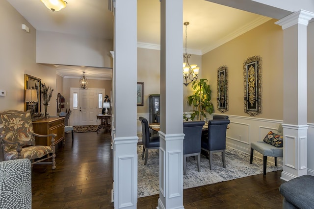 dining room featuring a chandelier, dark wood-type flooring, crown molding, and ornate columns