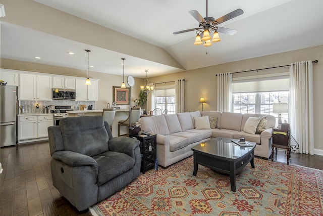 living room with vaulted ceiling, dark wood-type flooring, ceiling fan with notable chandelier, and recessed lighting