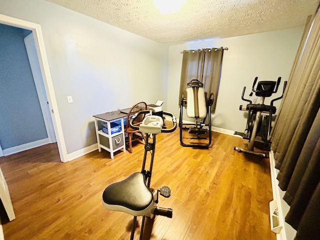 exercise room with hardwood / wood-style flooring and a textured ceiling