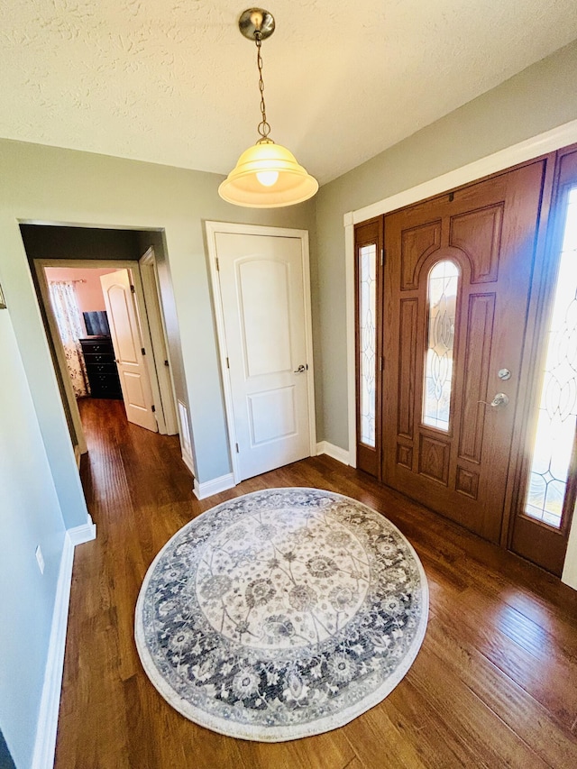 foyer featuring dark hardwood / wood-style flooring and a textured ceiling