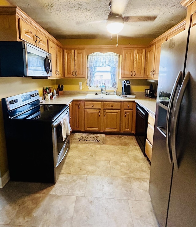 kitchen featuring sink, a textured ceiling, stainless steel appliances, and ceiling fan