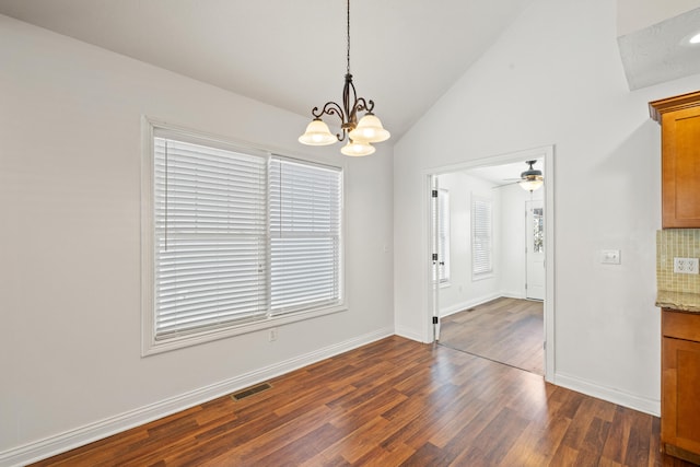 spare room featuring ceiling fan with notable chandelier, dark hardwood / wood-style flooring, and lofted ceiling