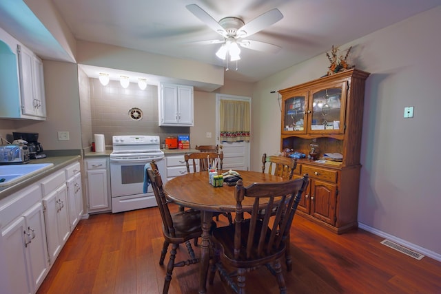 dining area featuring ceiling fan, sink, and dark hardwood / wood-style flooring