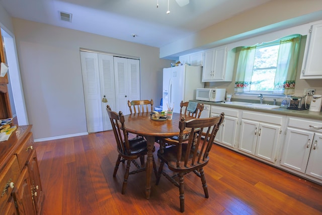 dining space featuring sink, ceiling fan, and dark hardwood / wood-style floors