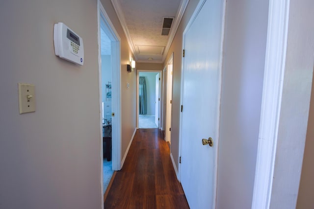 hall with a textured ceiling, dark hardwood / wood-style flooring, and ornamental molding