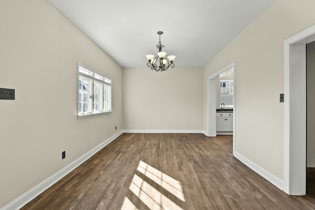 unfurnished dining area with dark wood-type flooring and a notable chandelier