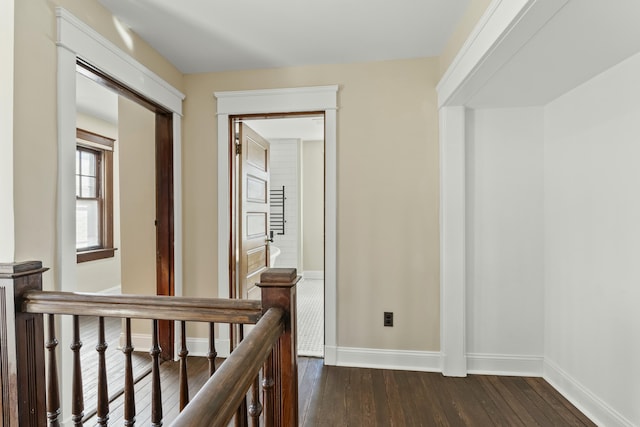 corridor with dark hardwood / wood-style flooring