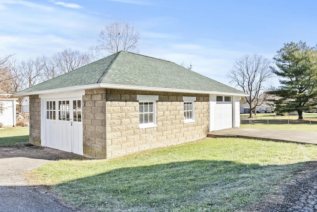 exterior space featuring an outbuilding, a garage, and a lawn