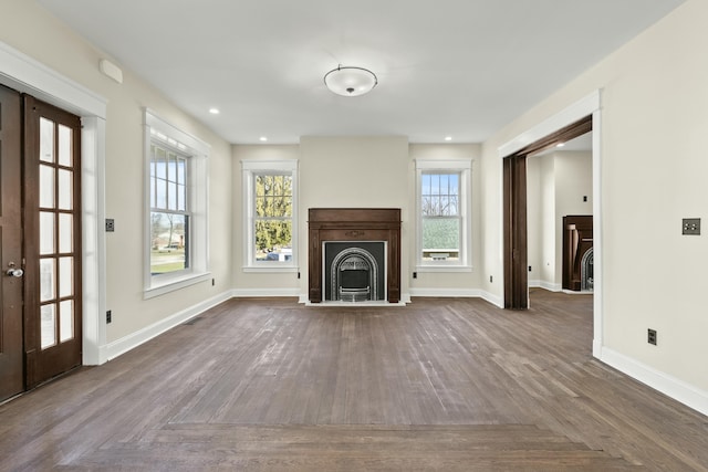 unfurnished living room with a healthy amount of sunlight and dark parquet flooring