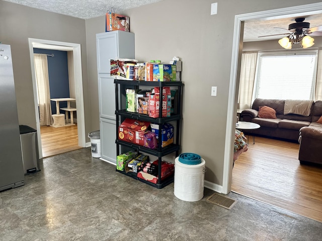 rec room with ceiling fan and a textured ceiling