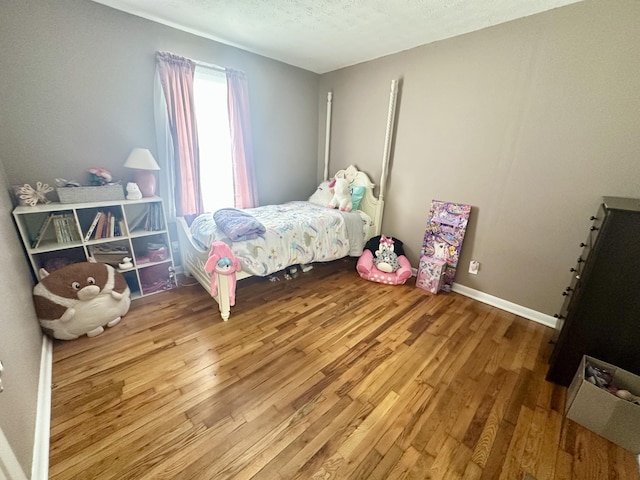 bedroom with wood-type flooring and a textured ceiling