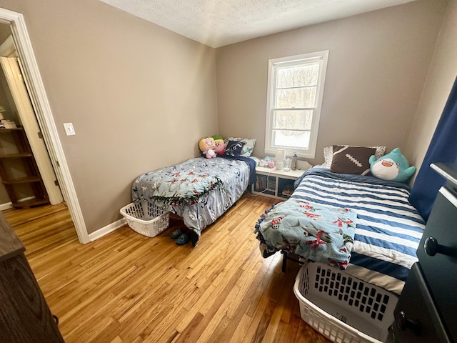 bedroom featuring a textured ceiling and light wood-type flooring