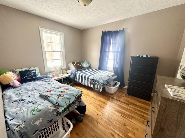 bedroom featuring light hardwood / wood-style floors and a textured ceiling