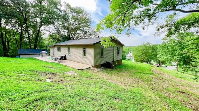 back of house with a yard and a patio