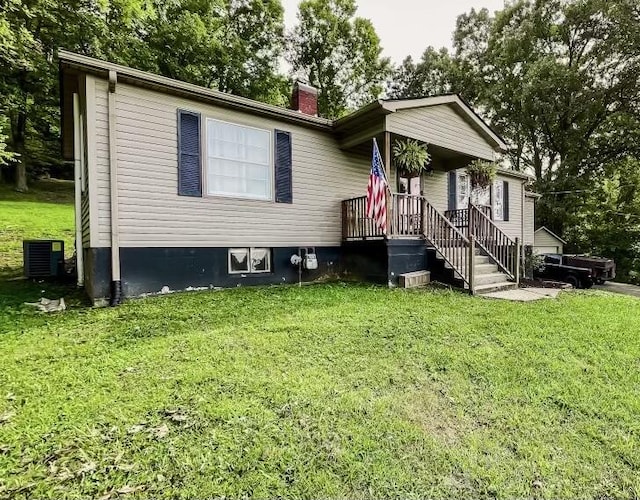 view of front of house with central AC and a front yard