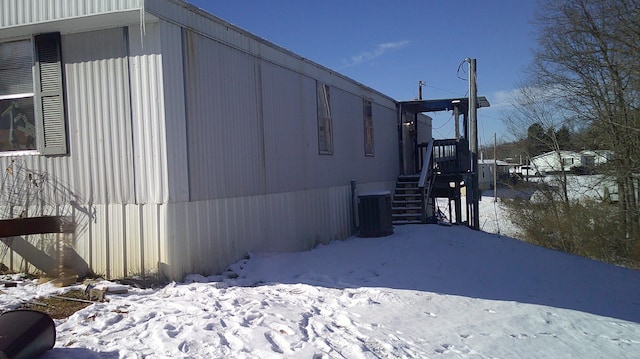 view of snow covered exterior with central AC