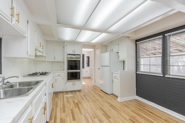 kitchen featuring white appliances, white cabinetry, decorative backsplash, sink, and light hardwood / wood-style flooring