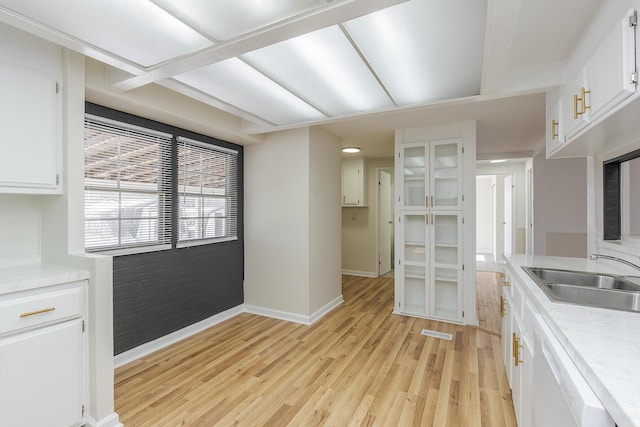 kitchen featuring sink, white cabinetry, dishwasher, and light wood-type flooring