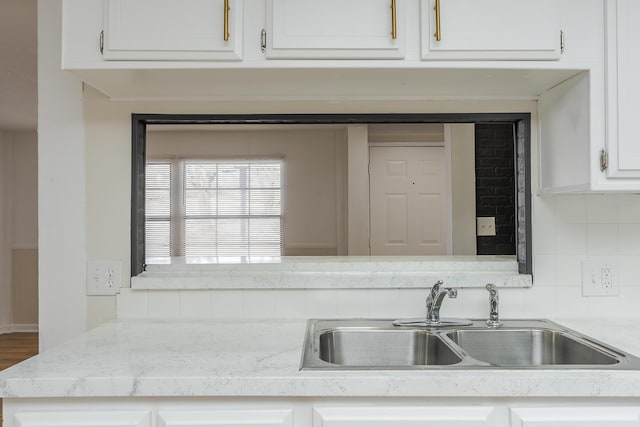 kitchen with sink, white cabinets, and tasteful backsplash