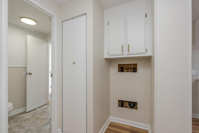 washroom with washer hookup and cabinets